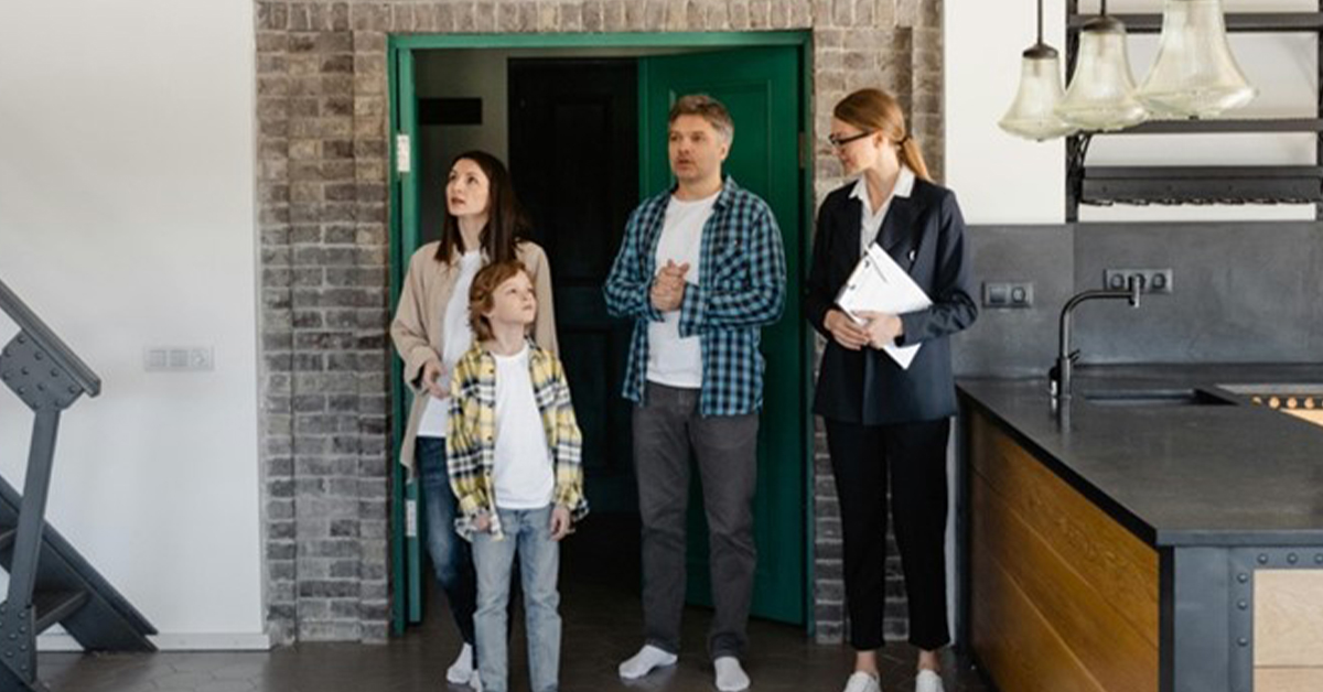 Real estate agent showing a family around a modern home